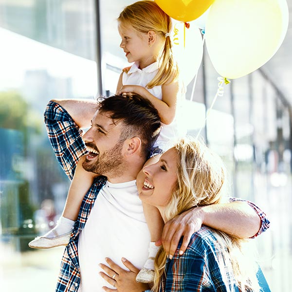 parents shopping with little girl holding balloon